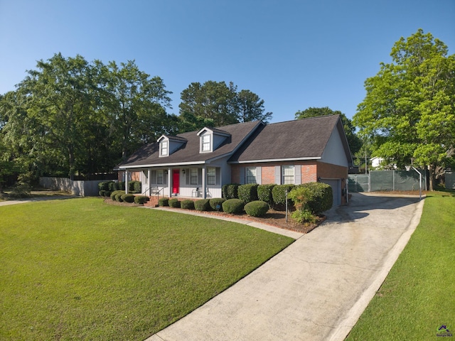 207 Oak Forest Ln, Warner Robins, GA 31088 - cape cod house featuring a porch, driveway, an attached garage, and brick siding