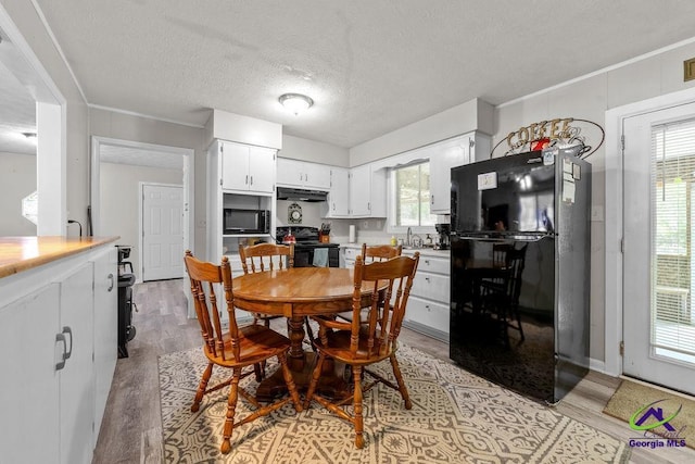 1322 Melford Dr, Columbus, GA 31907 - dining space with healthy amount of natural light, light wood-style flooring, and a textured ceiling