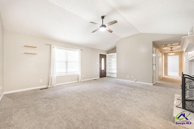 4407 Jones Rds, Macon, GA 31216 - unfurnished living room featuring a ceiling fan, carpet flooring, vaulted ceiling, and baseboards