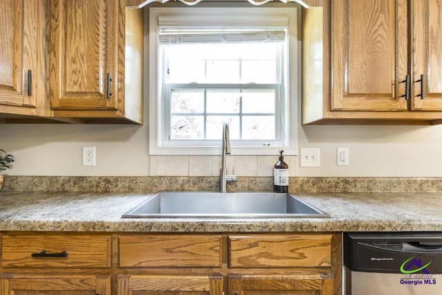 4407 Jones Rds, Macon, GA 31216 - kitchen featuring stainless steel dishwasher, a sink, brown cabinets, and light countertops