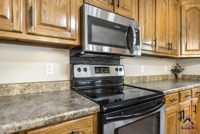 4407 Jones Rds, Macon, GA 31216 - kitchen featuring stainless steel appliances, brown cabinets, and dark countertops