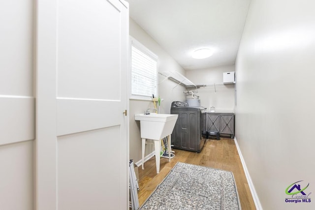 4407 Jones Rds, Macon, GA 31216 - laundry room with washer / clothes dryer, light wood-style flooring, and baseboards