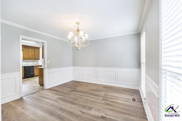 757 Silver Springs Drs, Macon, GA 31210 - unfurnished dining area featuring a chandelier, ornamental molding, a wainscoted wall, light wood finished floors, and a decorative wall