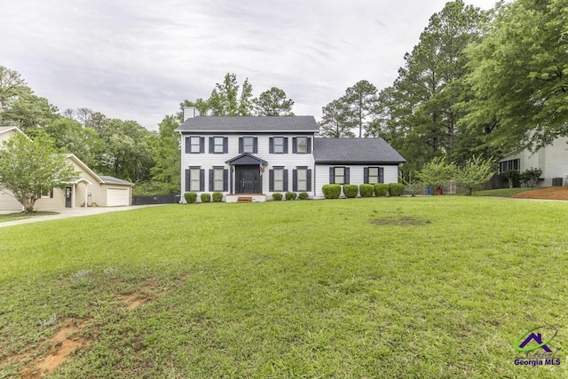 757 Silver Springs Drs, Macon, GA 31210 - colonial home with a chimney, a front yard, a detached garage, an outdoor structure, and roof with shingles