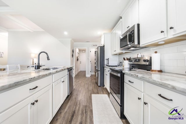 601 Hunts Landing Dr, Kathleen, GA 31047 - kitchen featuring stainless steel appliances, ornamental molding, a sink, white cabinetry, and dark wood finished floors