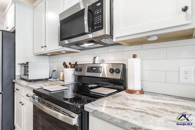 601 Hunts Landing Dr, Kathleen, GA 31047 - kitchen with stainless steel appliances, white cabinets, and tasteful backsplash