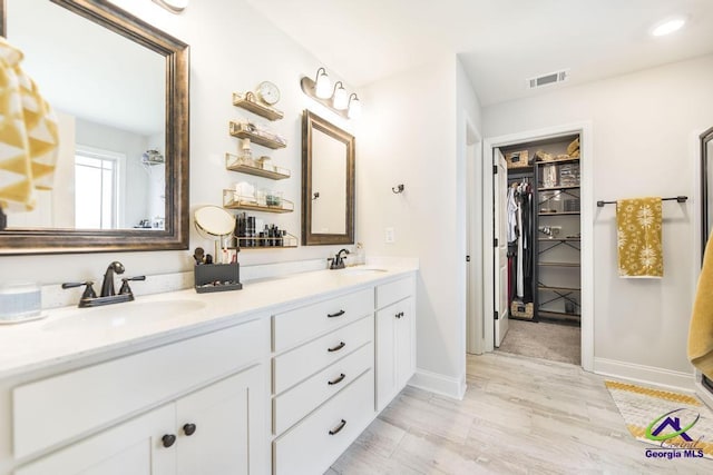 601 Hunts Landing Dr, Kathleen, GA 31047 - bathroom featuring double vanity, wood finished floors, a spacious closet, and baseboards