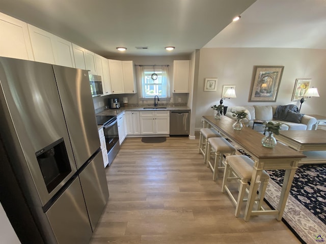 51 Cole Dr, Hawkinsville, GA 31036 - kitchen featuring appliances with stainless steel finishes, white cabinetry, a sink, light wood-style floors, and open floor plan