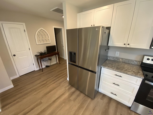 51 Cole Dr, Hawkinsville, GA 31036 - kitchen with stainless steel refrigerator with ice dispenser, range, white cabinetry, and light wood-type flooring