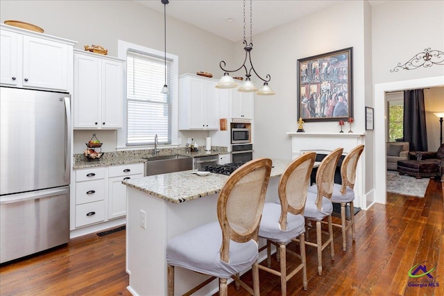 1360 Calhoun St, Macon, GA 31201 - kitchen featuring appliances with stainless steel finishes, a sink, dark wood finished floors, and white cabinets