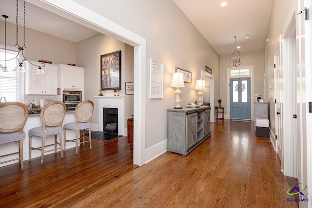 1360 Calhoun St, Macon, GA 31201 - foyer featuring wood finished floors, a chandelier, baseboards, a fireplace with raised hearth, and recessed lighting