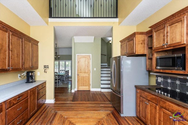 283 Limestone Rd, Cochran, GA 31014 - kitchen featuring stainless steel appliances, baseboards, brown cabinets, and backsplash