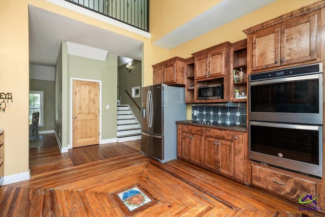 283 Limestone Rd, Cochran, GA 31014 - kitchen featuring appliances with stainless steel finishes, open shelves, dark countertops, baseboards, and backsplash