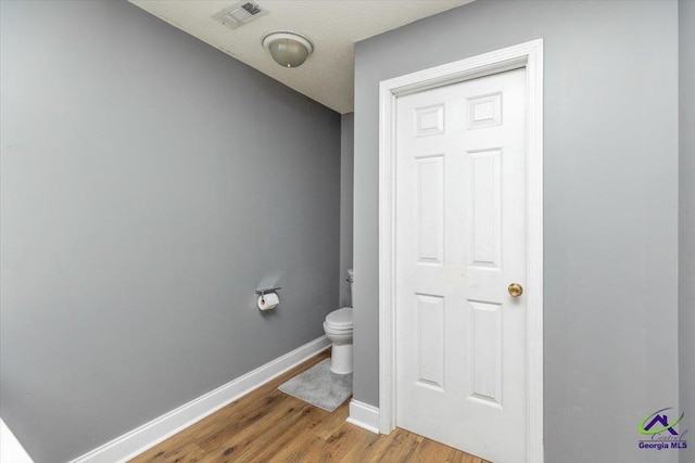 283 Limestone Rd, Cochran, GA 31014 - bathroom featuring toilet, baseboards, and wood finished floors
