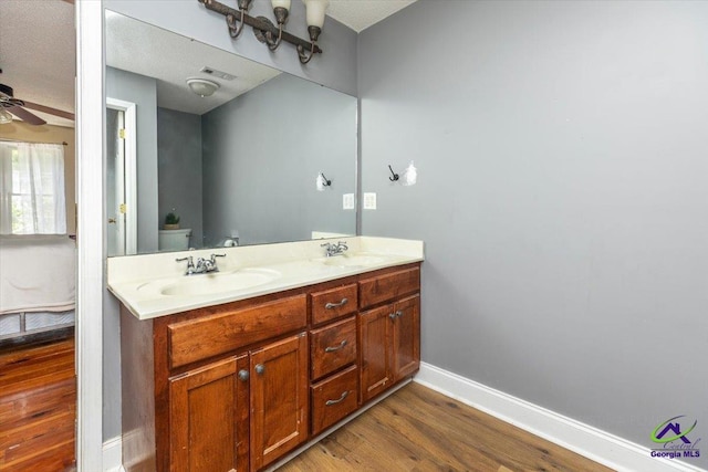 283 Limestone Rd, Cochran, GA 31014 - full bath with double vanity, wood finished floors, a ceiling fan, toilet, and baseboards