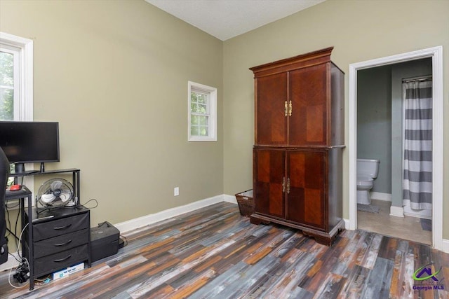 283 Limestone Rd, Cochran, GA 31014 - bedroom featuring dark wood-type flooring, multiple windows, baseboards, and ensuite bathroom