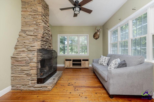 283 Limestone Rd, Cochran, GA 31014 - living room featuring ceiling fan, baseboards, hardwood / wood-style floors, and a stone fireplace