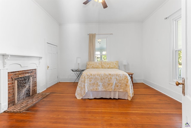 110 Minor Ave, Montezuma, GA 31063 - bedroom featuring crown molding, hardwood / wood-style floors, a brick fireplace, baseboards, and a ceiling fan