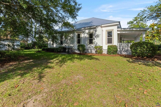 110 Minor Ave, Montezuma, GA 31063 - view of front facade with a front yard, a porch, metal roof, and a carport