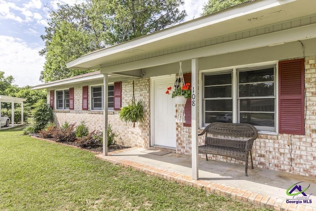 108 Marcia Ct, Warner Robins, GA 31088 - doorway to property featuring brick siding, a lawn, and a porch