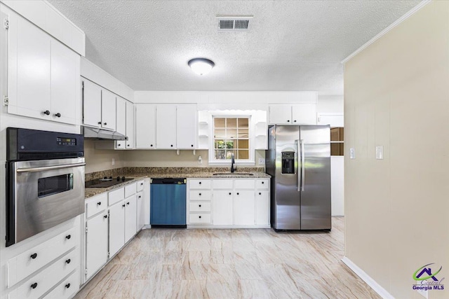 214 Markwood Dr, Warner Robins, GA 31093 - kitchen with stainless steel appliances, a sink, white cabinetry, under cabinet range hood, and a textured ceiling