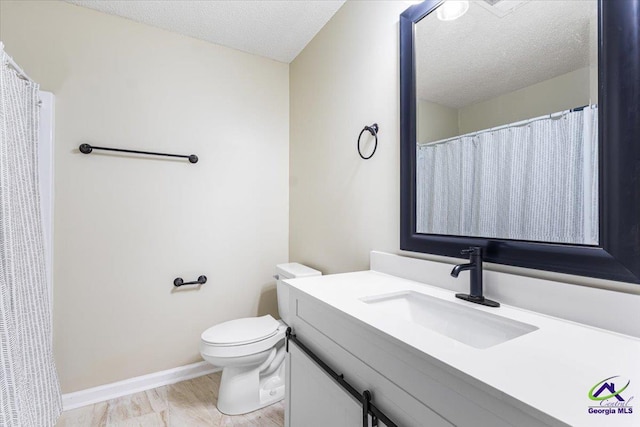 214 Markwood Dr, Warner Robins, GA 31093 - bathroom with vanity, toilet, a textured ceiling, baseboards, and wood finished floors