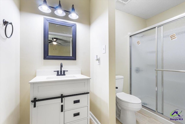 214 Markwood Dr, Warner Robins, GA 31093 - bathroom featuring vanity, toilet, a shower stall, a textured ceiling, and wood finished floors