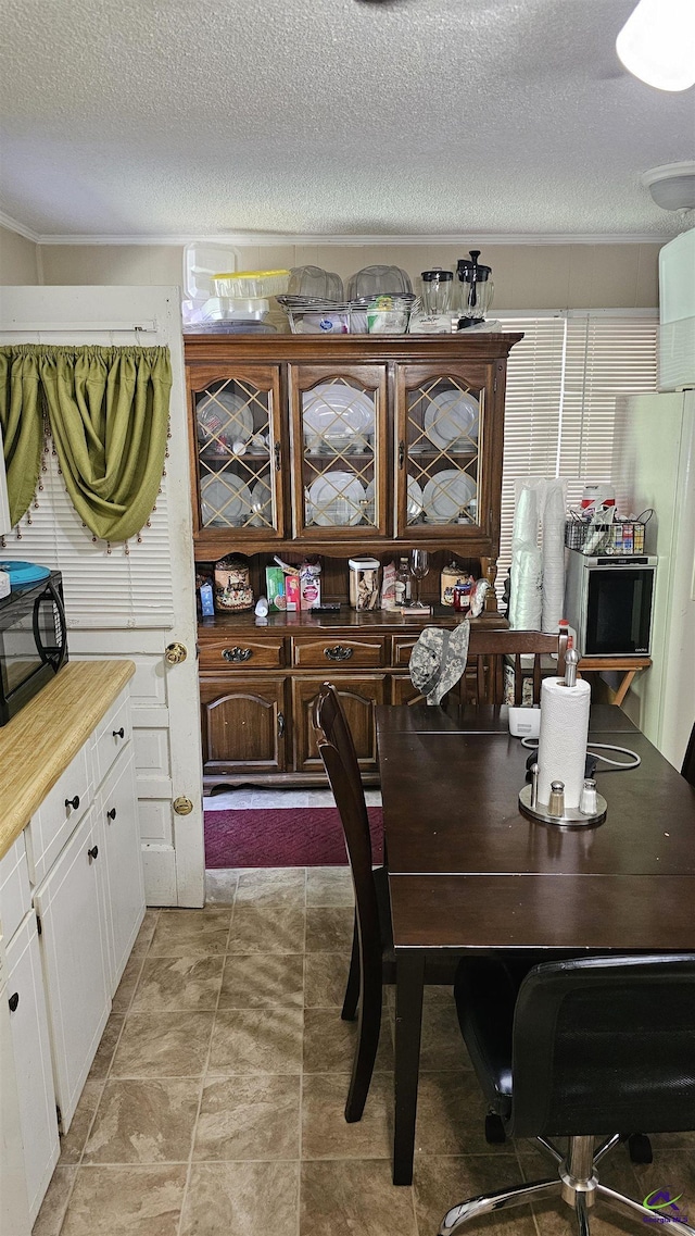 129 Tinker Blvd, Warner Robins, GA 31093 - dining space featuring a textured ceiling and crown molding