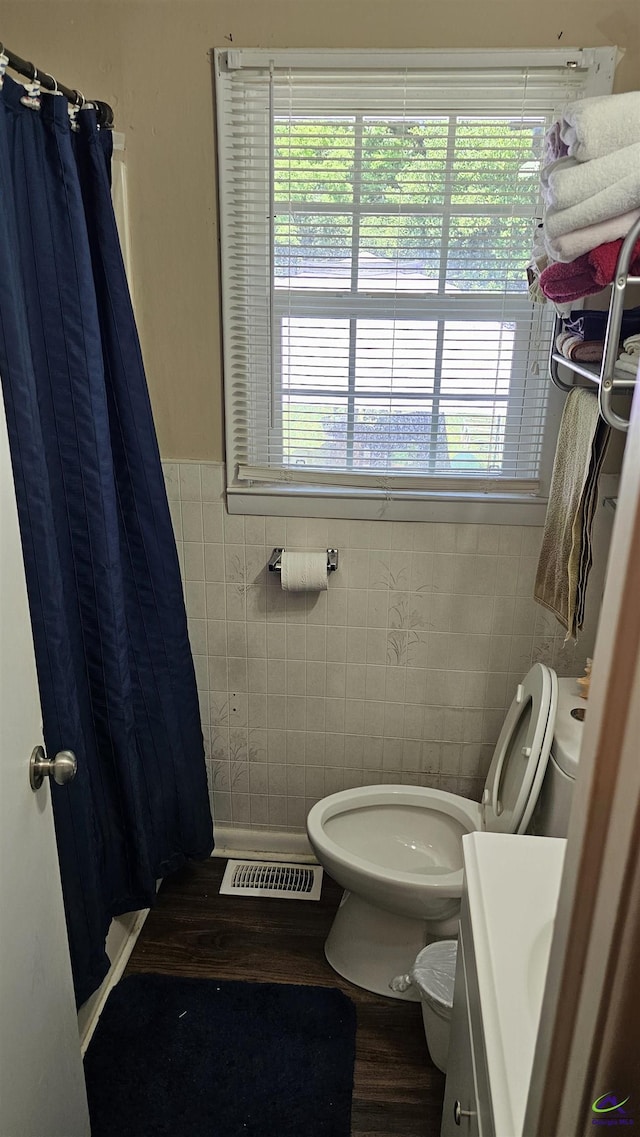 129 Tinker Blvd, Warner Robins, GA 31093 - full bath with tile walls, vanity, wood finished floors, toilet, and a shower with shower curtain