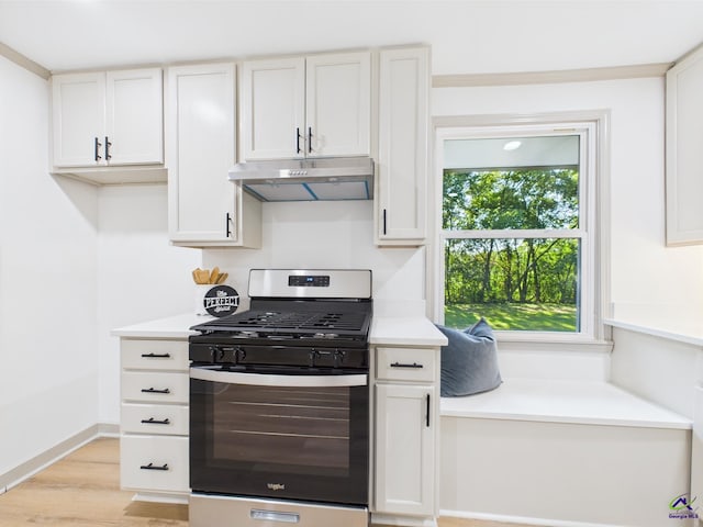 744 Corbin Ave, Macon, GA 31204 - kitchen with stainless steel range with gas cooktop, under cabinet range hood, light countertops, light wood finished floors, and white cabinets