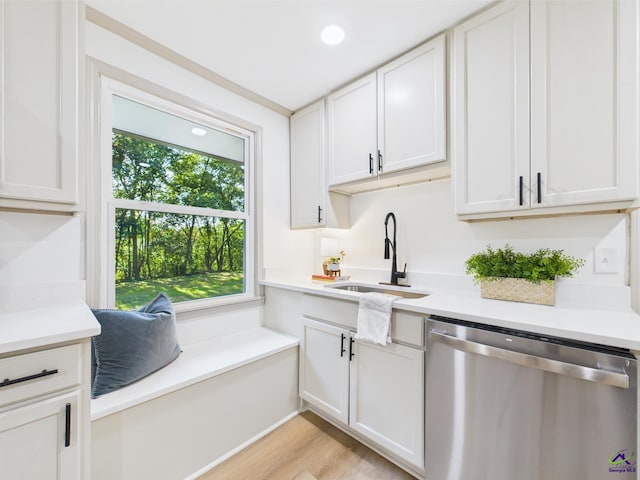 744 Corbin Ave, Macon, GA 31204 - kitchen with stainless steel dishwasher, a sink, light wood-style flooring, and light countertops
