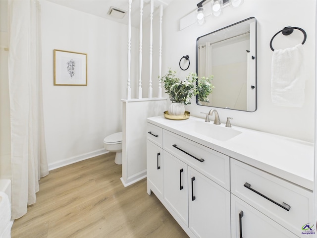 3081 Tiffin Cir, Macon, GA 31204 - full bathroom with toilet, vanity, wood finished floors, and baseboards