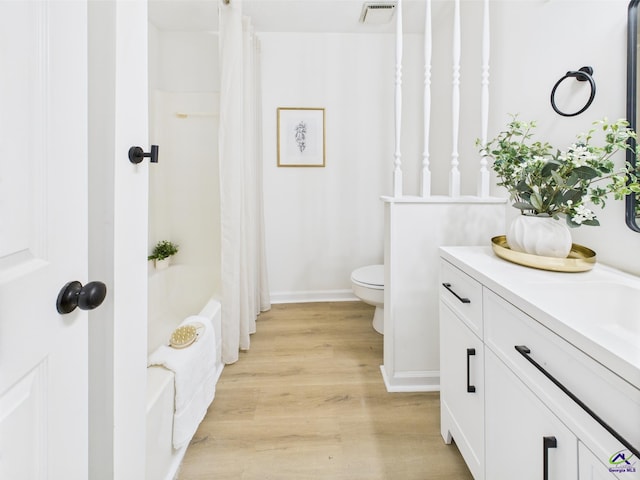 3081 Tiffin Cir, Macon, GA 31204 - bathroom featuring wood finished floors, toilet, vanity, shower / bathtub combination with curtain, and baseboards