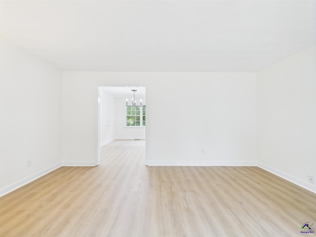 3081 Tiffin Cir, Macon, GA 31204 - empty room featuring light wood finished floors, a chandelier, and baseboards