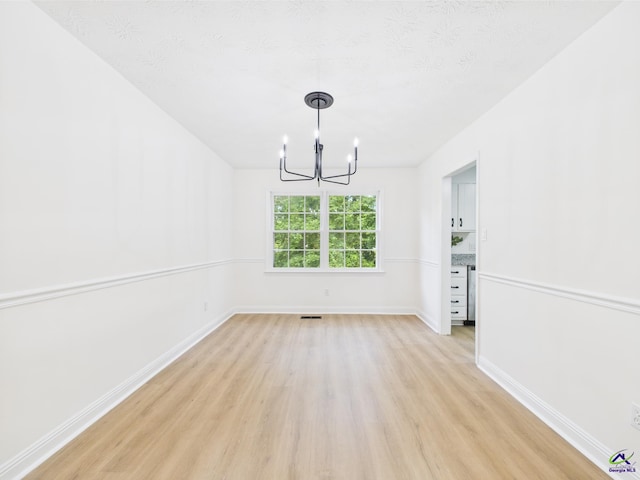 3081 Tiffin Cir, Macon, GA 31204 - unfurnished dining area featuring light wood-type flooring, a chandelier, baseboards, and a textured ceiling