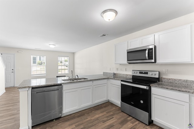 630 Ivy Brook Way, Macon, GA 31210 - kitchen with stainless steel appliances, a sink, a peninsula, dark wood-style floors, and white cabinets