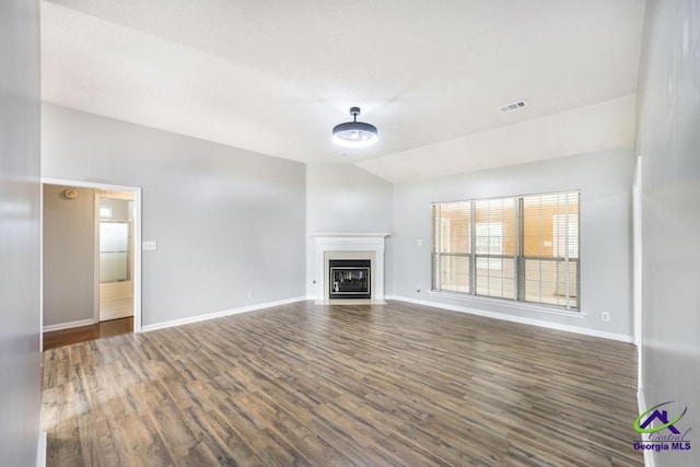 319 Smithville Church Rd, Warner Robins, GA 31088 - unfurnished living room featuring lofted ceiling, baseboards, wood finished floors, and a fireplace with flush hearth