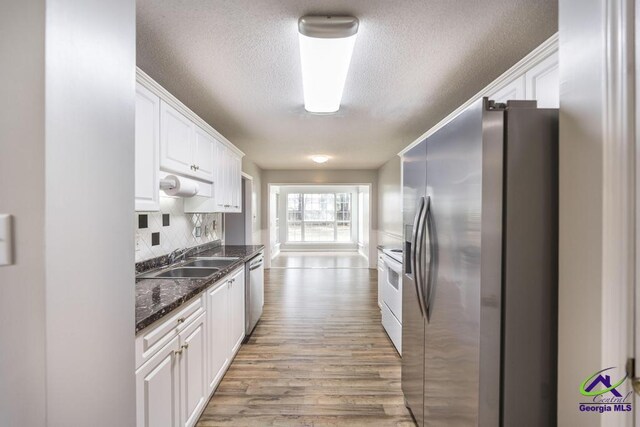 319 Smithville Church Rd, Warner Robins, GA 31088 - kitchen featuring appliances with stainless steel finishes, a sink, a textured ceiling, white cabinetry, and light wood-style flooring