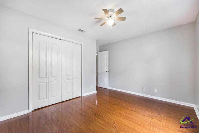 319 Smithville Church Rd, Warner Robins, GA 31088 - unfurnished bedroom with a closet, baseboards, wood finished floors, and a ceiling fan