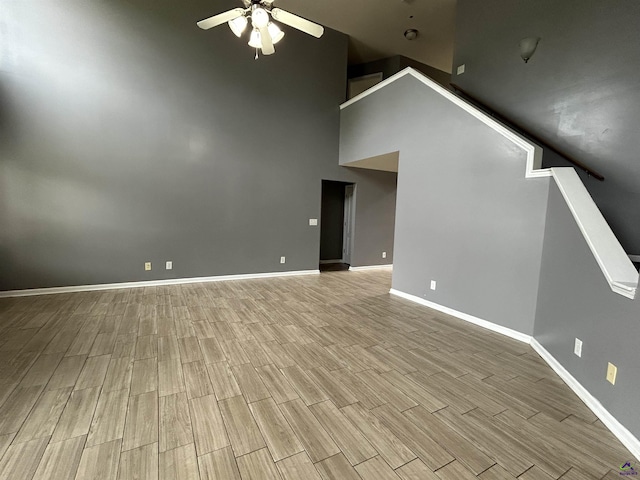 103 Lattice Bnd, Bonaire, GA 31005 - unfurnished living room with a ceiling fan, a high ceiling, wood finished floors, baseboards, and stairs