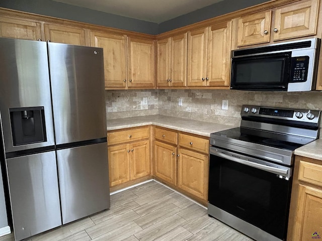103 Lattice Bnd, Bonaire, GA 31005 - kitchen with appliances with stainless steel finishes, light countertops, tasteful backsplash, light wood-style flooring, and brown cabinets