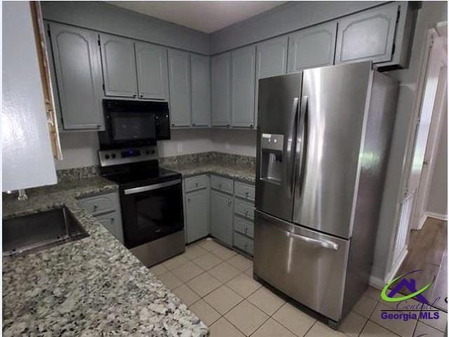 115 Friar Tuck Ave, Warner Robins, GA 31088 - kitchen featuring stainless steel appliances, light stone counters, light tile patterned flooring, and a sink