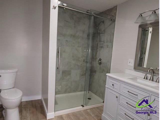 115 Friar Tuck Ave, Warner Robins, GA 31088 - full bath with toilet, a shower stall, vanity, and wood finished floors