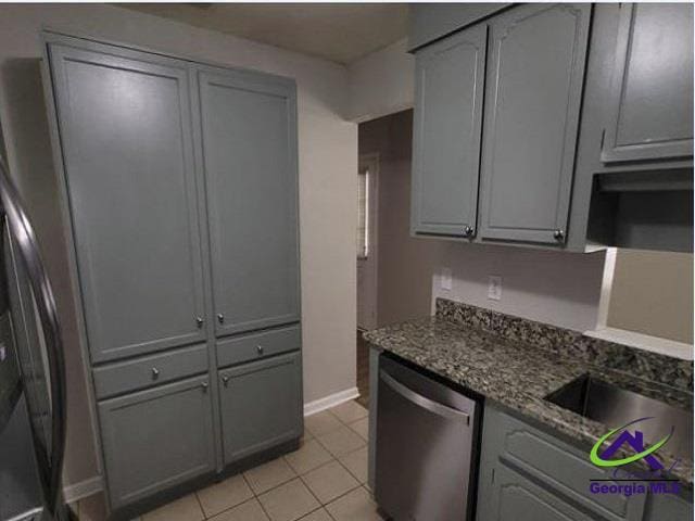 115 Friar Tuck Ave, Warner Robins, GA 31088 - kitchen with dishwasher, gray cabinetry, light tile patterned floors, baseboards, and dark stone countertops