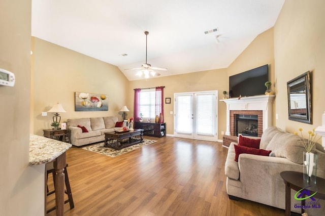 201 Loudon Hill Dr, Warner Robins, GA 31088 - living room featuring vaulted ceiling, ceiling fan, wood finished floors, a fireplace, and baseboards