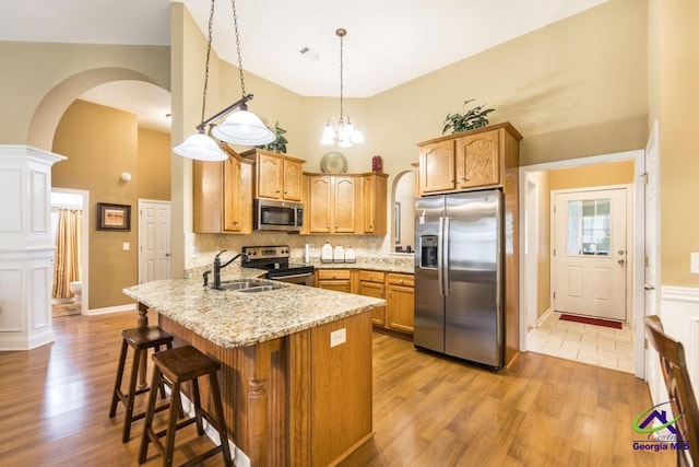 201 Loudon Hill Dr, Warner Robins, GA 31088 - kitchen featuring stainless steel appliances, a high ceiling, arched walkways, a sink, and a peninsula