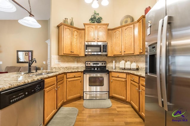 201 Loudon Hill Dr, Warner Robins, GA 31088 - kitchen with stainless steel appliances, a sink, tasteful backsplash, light wood-type flooring, and light stone counters