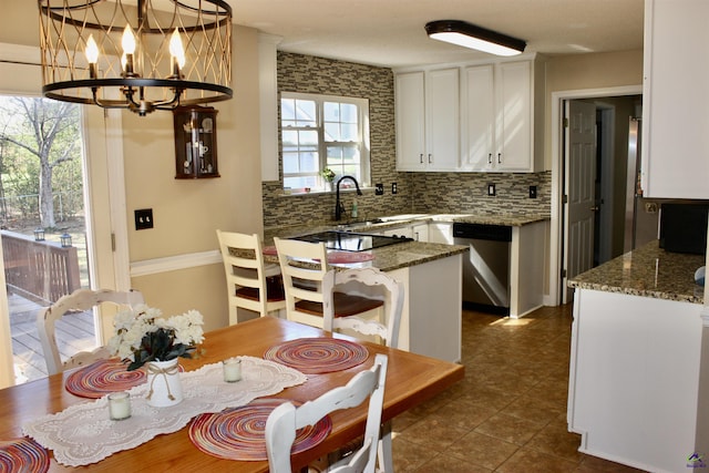 303 Shane, Perry, GA 31069 - kitchen featuring stainless steel dishwasher, white cabinetry, a chandelier, tasteful backsplash, and a peninsula