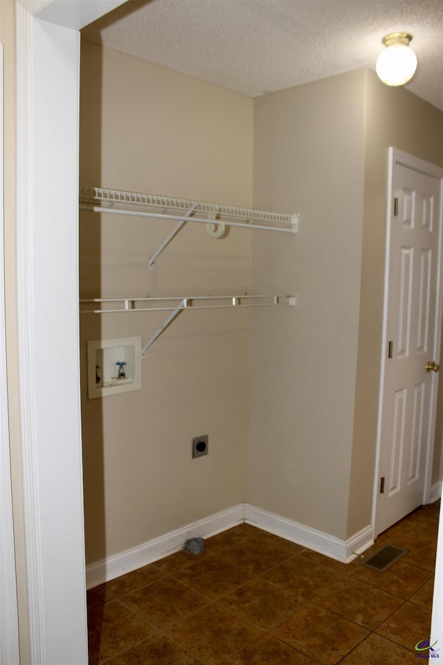 303 Shane, Perry, GA 31069 - washroom featuring washer hookup, electric dryer hookup, tile patterned flooring, baseboards, and a textured ceiling