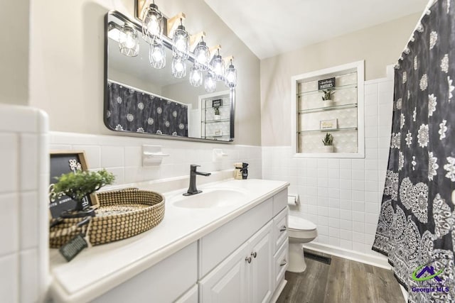 123 Robinhood Dr, Warner Robins, GA 31088 - bathroom with tile walls, vanity, wood finished floors, toilet, and a shower with shower curtain